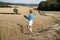 Woman surveying field of wheat UK