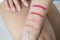 Woman swatch cosmetic products on arm