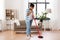 Woman with sweeping broom brush cleaning floor