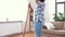 Woman with sweeping broom brush cleaning floor