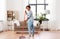 Woman with sweeping broom brush cleaning floor