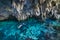 Woman swimming in natural lake inside cave. Colorful reflection, turquoise transparent water, summer adventures. Tourist