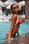 woman in swimming pool. Beautiful girl in the red bikini on the sun-tanned slim and shapely body