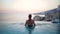 Woman In Swimming Pool Spa Enjoying Sunset On Over Sea Luxury Vacation Travel in Greece, Europe. Girl in bikini watching