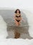 woman in swimming suit closeup photo on ice hole snowy winter background
