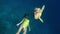 Woman swimming underwater with turtle in pristine blue ocean water, amazing snorkeling adventure. Girl spend her