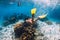 Woman swimming underwater with yellow fins in ocean. Freediving or snorkeling in Mauritius