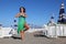 Woman in swimsuit and pareo stands on beach