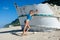 Woman in swimwear walking on sandy beach during daytime near broken ship