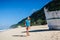 Woman in swimwear walking on sandy beach during daytime near broken ship