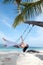 Woman on the swing on the beach in white dress