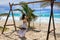 Woman on a swing at a caribbean beach, Tulum