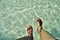 Woman swinging her feet in crystal clear water