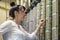 The woman switches the wires on the communication panel to the date of the center. The technician works on the switchboard