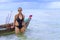 Woman symbol black bikini and small boat on beach