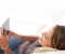 Woman, tablet and couch for social media and scroll, smile and relax on vacation or weekend. Technology, network and