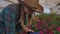 A woman with a tablet examines the flowers and presses her fingers on the tablet screen. Flower farming business