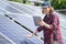 Woman with tablet touching solar panel