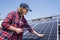 Woman with tablet touching solar panel