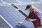 Woman with tablet touching solar panel