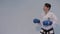 Woman taekwondo fighter trains shadow boxing punches and kicks. Girl wearing in white kimono performing martial arts