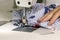 Woman tailor sews fabric on a sewing machine in the workshop.