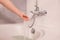 Woman take bath checking temperature touching running water with hand. fingers under hot water out of a faucet of a sink or