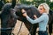 Woman take caring for the hair of brown horse