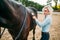 Woman take caring for the hair of brown horse