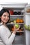 Woman take green apple from fridge