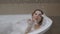 Woman takes a Bath and Playing with Soap Foam.