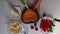 A woman takes a biscuit from a baking dish. Next to the saucer is a strawberry and there is a cream.