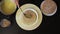 Woman takes a cake, puts it on another piece and smears cream on top of a cake which is on a round wooden spinning tray