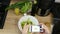 Woman takes photo on smart phone and puts in frame leaves of green salad and cucumber with red tomato