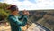 Woman takes a picture of Anasazi Cliff Dwellings With Her Smartphone
