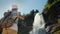 Woman takes pictures of majestic Steinsdalsfossen is a waterfall in the west of Norway