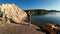 A woman takes pictures of a picturesque lake in the early morning