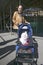 Woman takes white dog in baby buggy for a walk down Central Park in Manhattan, New York City, New York