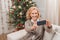 Woman takign selfie with christmas tree