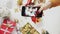 Woman taking beautiful picture on the smart phone. Female hands photogtaphing Christmas present on white table. Vertical