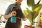 Woman taking care of home plant indoors