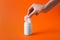 Woman taking chewing gums from jar on orange background, closeup