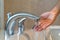 Woman taking home bath checking water temperature