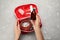 Woman taking medicine from first aid kit and different images at grey table, top view