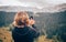 Woman taking panoramic picture of mountain landscape. Selfie photo stick