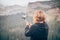 Woman taking panoramic picture of mountain landscape. Selfie photo stick