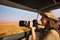 Woman taking photo aboard safari jeep at savannah