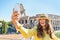 Woman taking photo with cell phone in rome