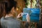 Woman taking photo of painting on canvas stand in garden