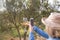 Woman taking a photo of wine glass in olives farm